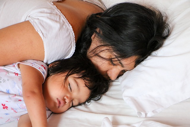 A mom and her baby peacefully sleeping together, illustrating the importance of rest in managing 'mommy brain' challenges and enhancing maternal well-being.